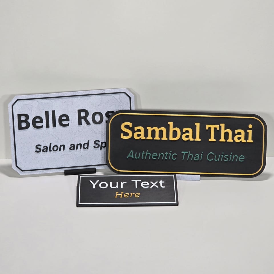 Front arrangement of three customizable business plaques in marble-white, black, and black-and-white finishes.