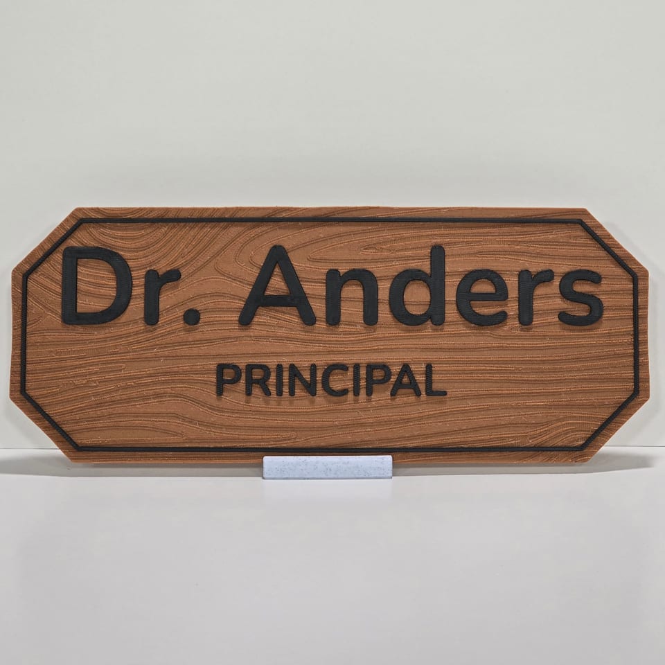 Wood-look staff nameplate reading Dr. Anders and Principal on a marble-white tabletop stand.