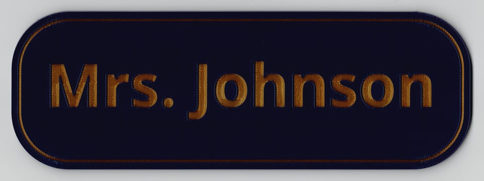 Direct scan of a matte navy blue Mrs. Johnson teacher name sign with engraved silk gold wording, matching border, and rounded corners.