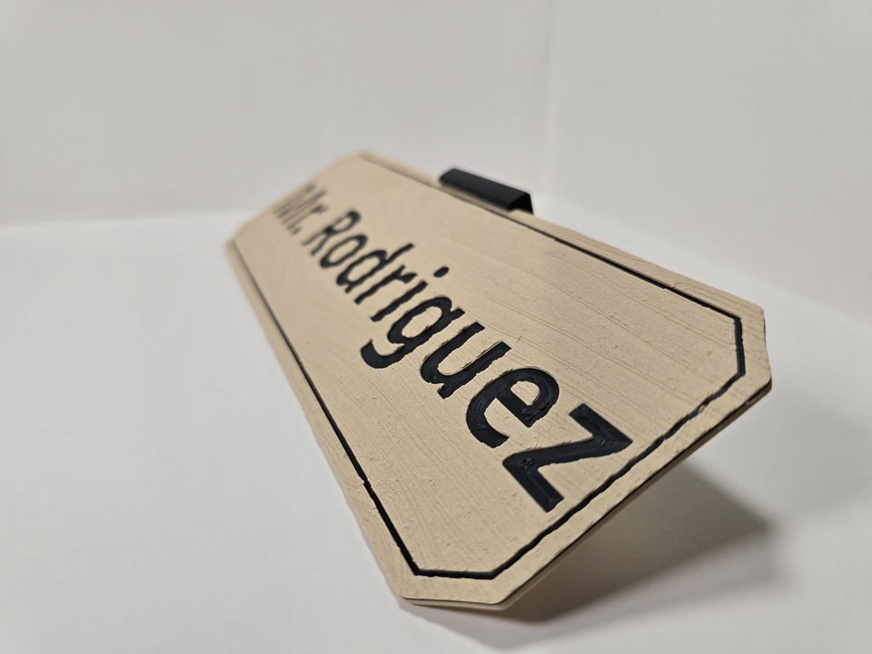 Close perspective of a wood-finish Teacher and Staff Nameplate reading Mr. Rodriguez, showing engraved black lettering, border, angled corners, and black tabletop stand.