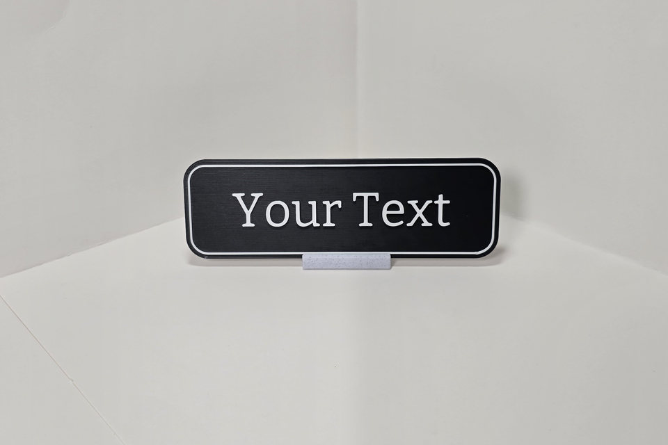 Black and white Teacher and Staff Nameplate sample reading Your Text on a marble-white tabletop stand.
